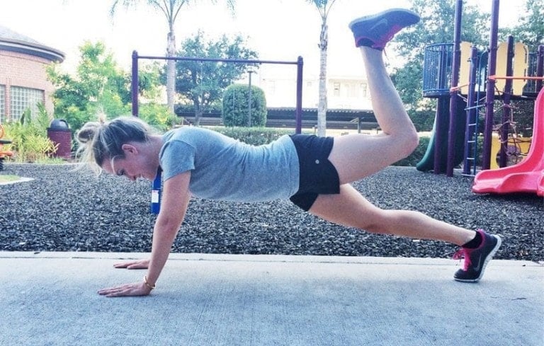 Woman doing donkey kick planks exercise.
