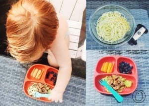 A child is seated with a plate of food, which includes zoodles, blueberries, a few carrot sticks, and meat served in a red divided plate with a blue fork on the side. To the right, there are images of zoodles in a clear bowl and the same plate with food.