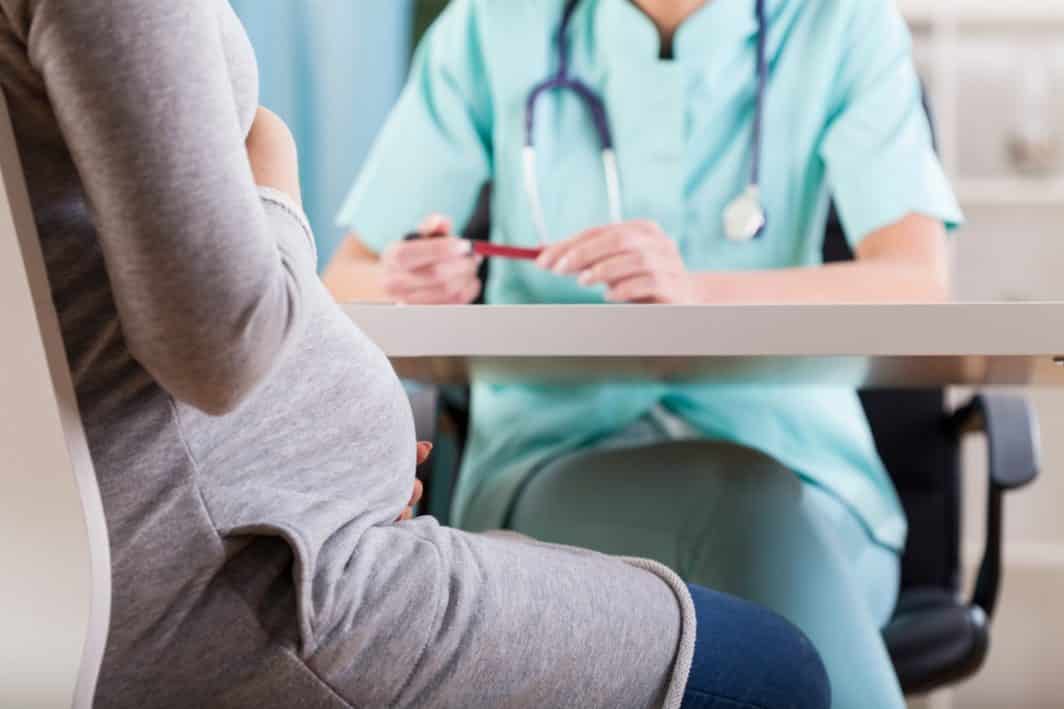 pregnant woman talking with her doctor.
