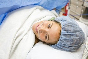 Mother smiling at view with her Newborn following surgery.