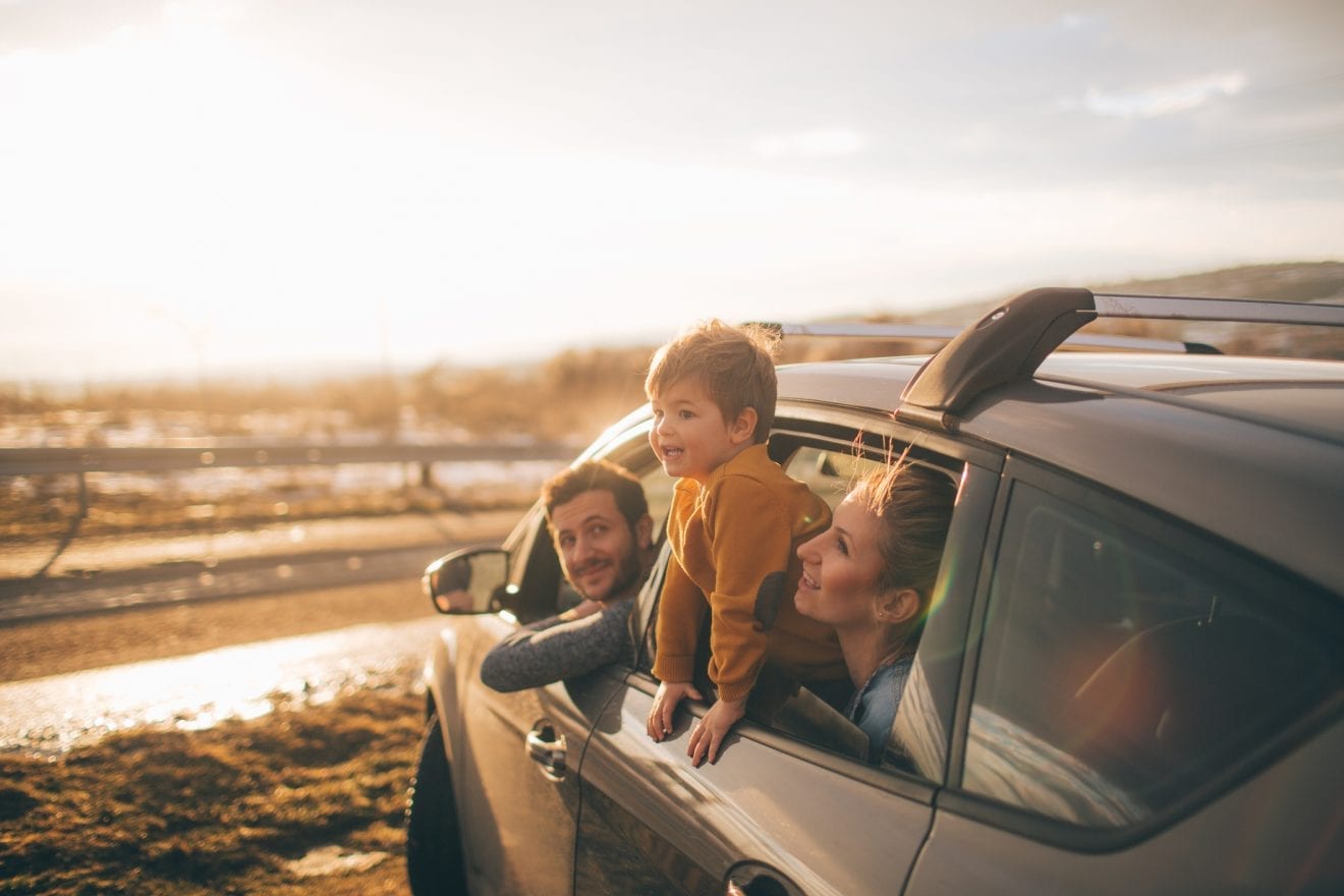 Photo of cute little family during their excursion with family car
