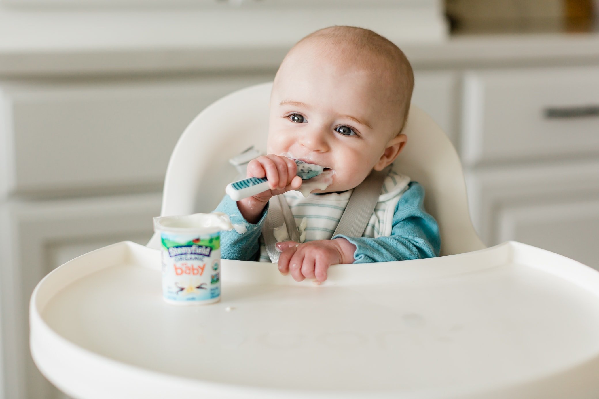 Baby eating stonyfield yobaby yogurt.