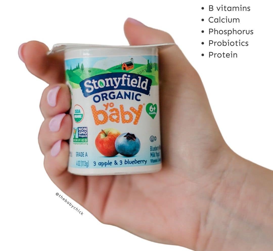 Hand holding Stonyfield yobaby yogurt.