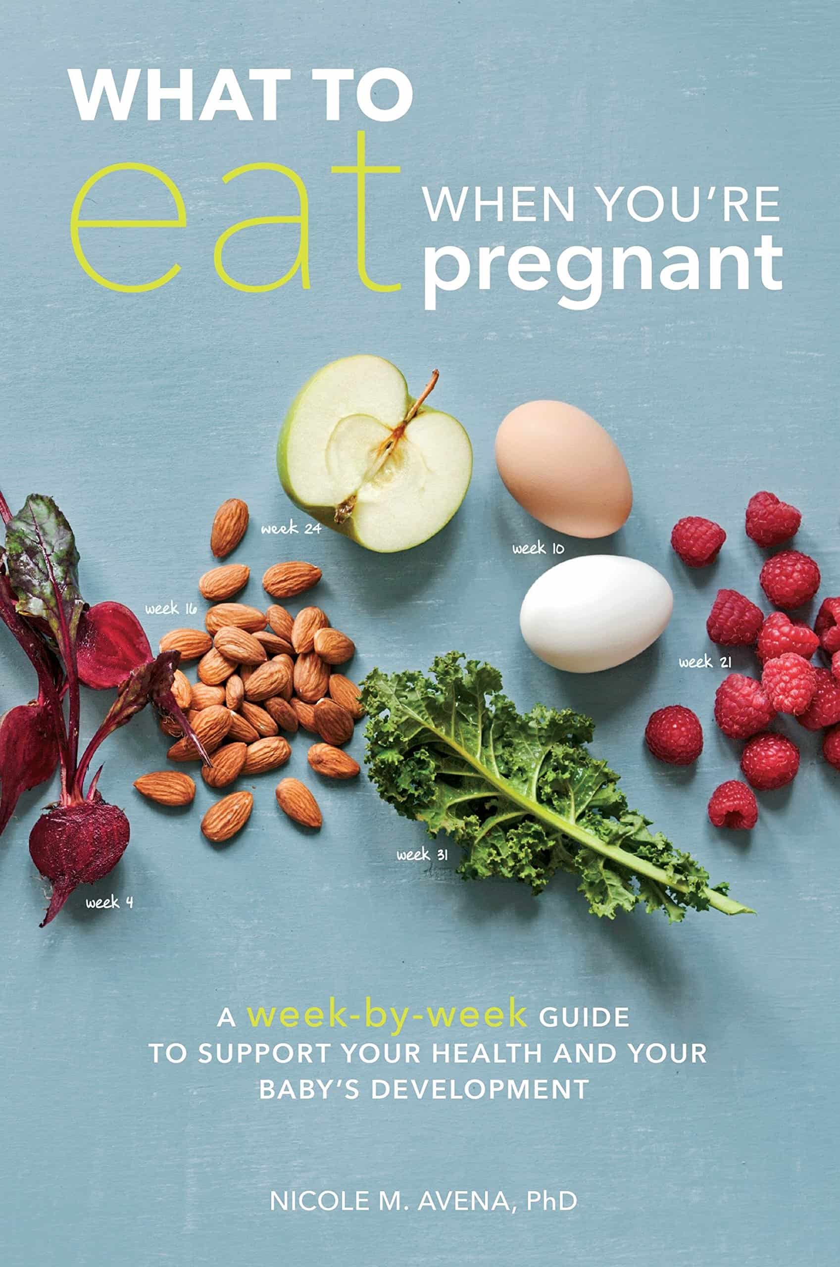 The cover of the pregnancy book "What to Eat When You're Pregnant" by Nicole M. Avena, PhD, features various healthy foods, including beets, almonds, an apple slice, a hard-boiled egg, raspberries, and kale, all arranged on a light blue background.