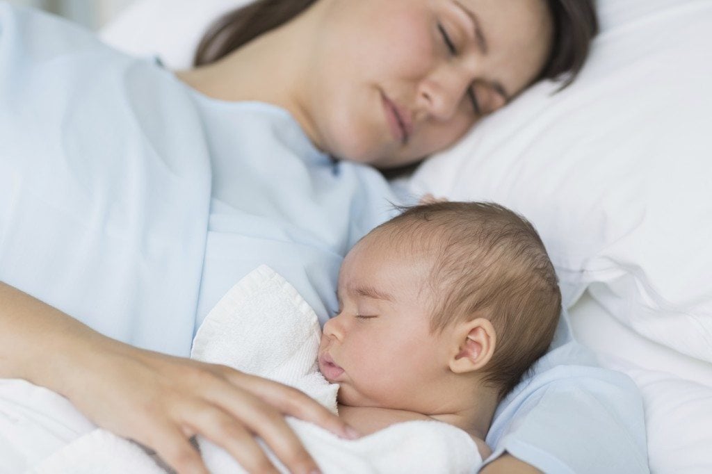 Mother and baby boy sleeping in the same hospital bed
