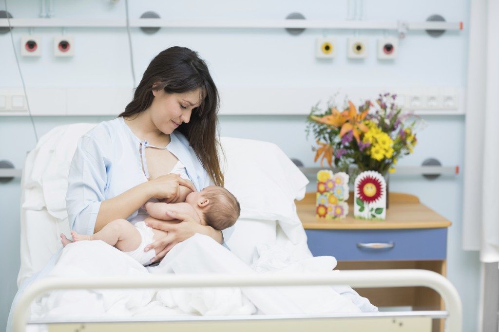 Mother breastfeeding a baby in a hospital room
