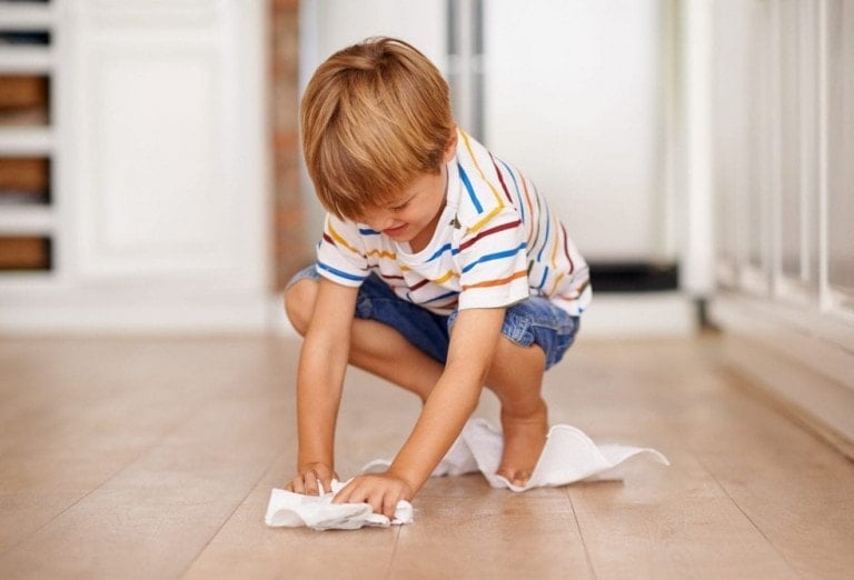 Little boy cleaning the floor with a paper towel