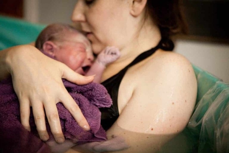 Mom holding baby after water birth
