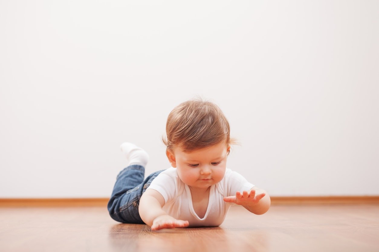 Cute baby boy on the floor trying to crawl