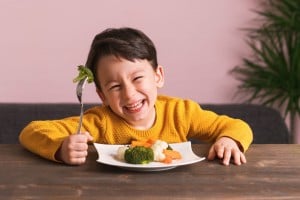 Happy child eating his vegetables.
