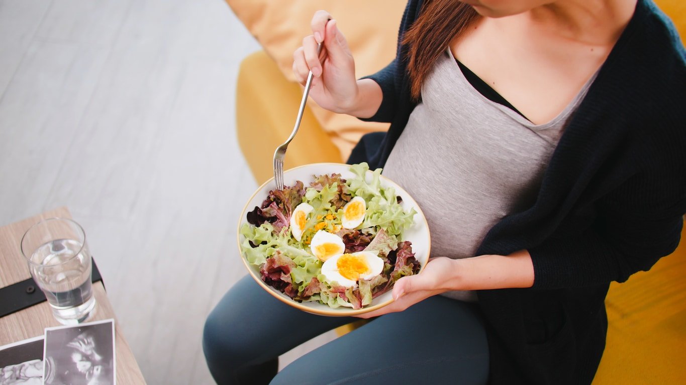 pregnant woman eats healthy food for her unborn baby