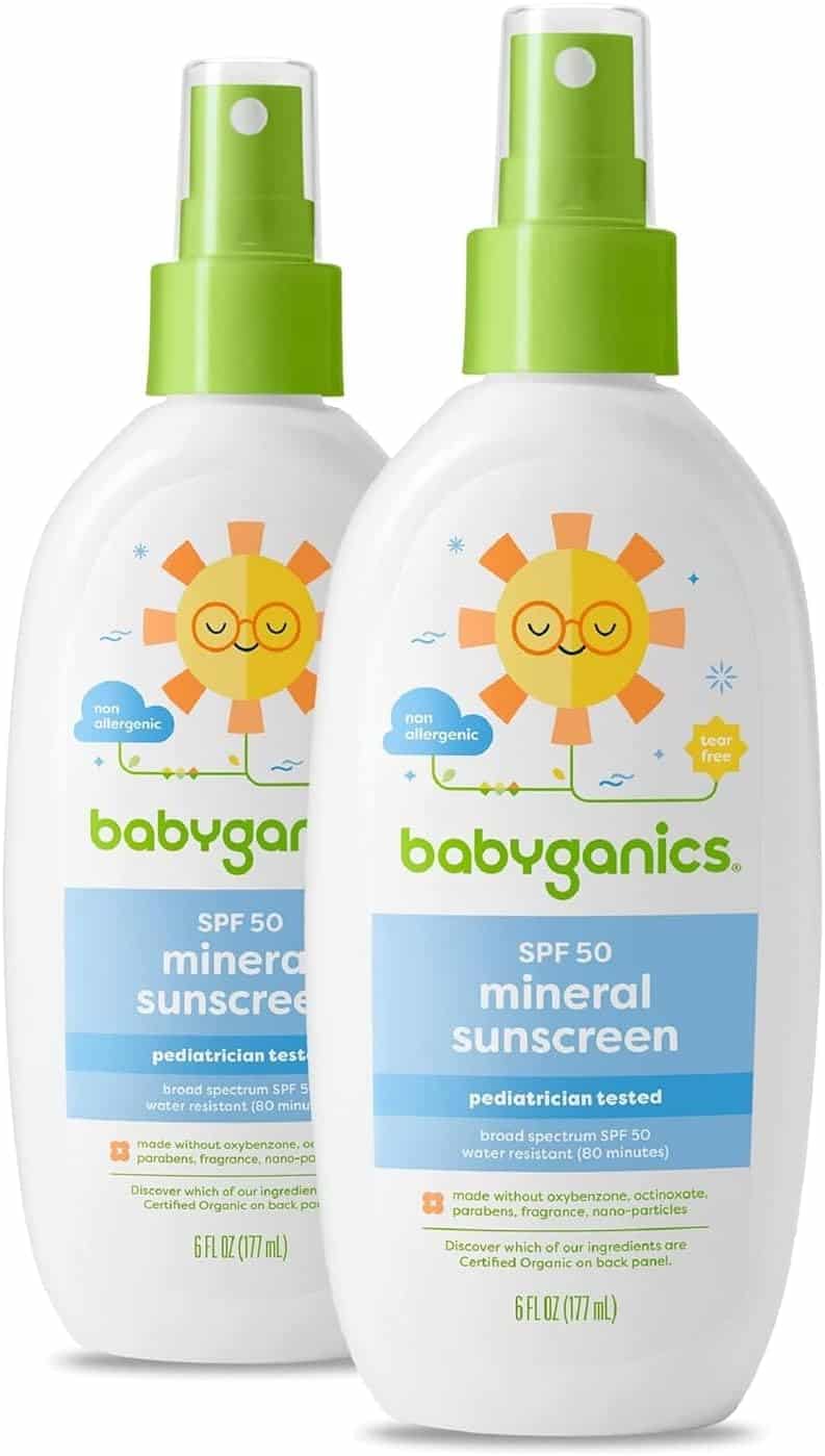 Here is your text with all single and double quote characters removed: Two bottles of Babyganics SPF 50 mineral sunscreen, a summer must-have, with green spray tops. The label features a sun illustration and notes pediatrician tested, broad spectrum SPF 50, and tear free. Each bottle is 6 fl oz (177 ml).