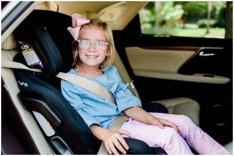 Young girl sitting in her NUNA EXEC all-in-one car seat.