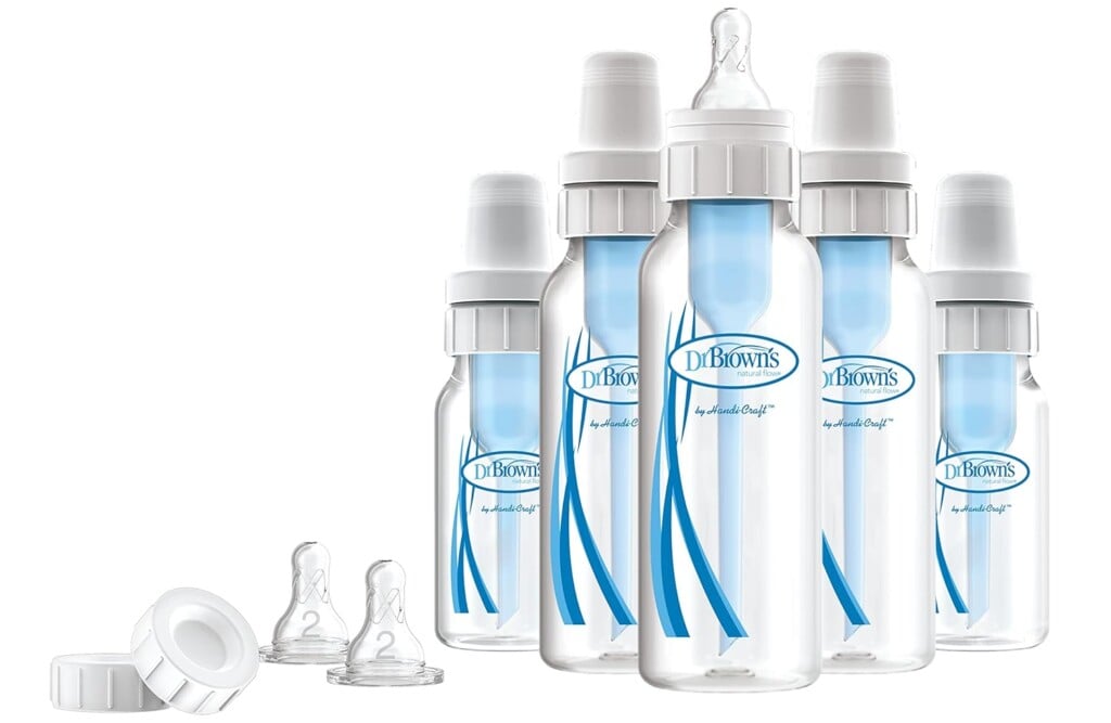 An arrangement of five Dr. Brown's baby bottles with blue accents, essential for postpartum care. Some bottles have caps on, while others have nipples exposed. Two additional bottle caps and two separate nipples are placed beside the bottles, completing your postpartum essentials collection.