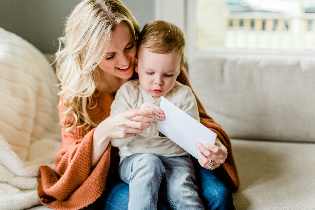 Mother and toddler son opening their Mootsh envelope.