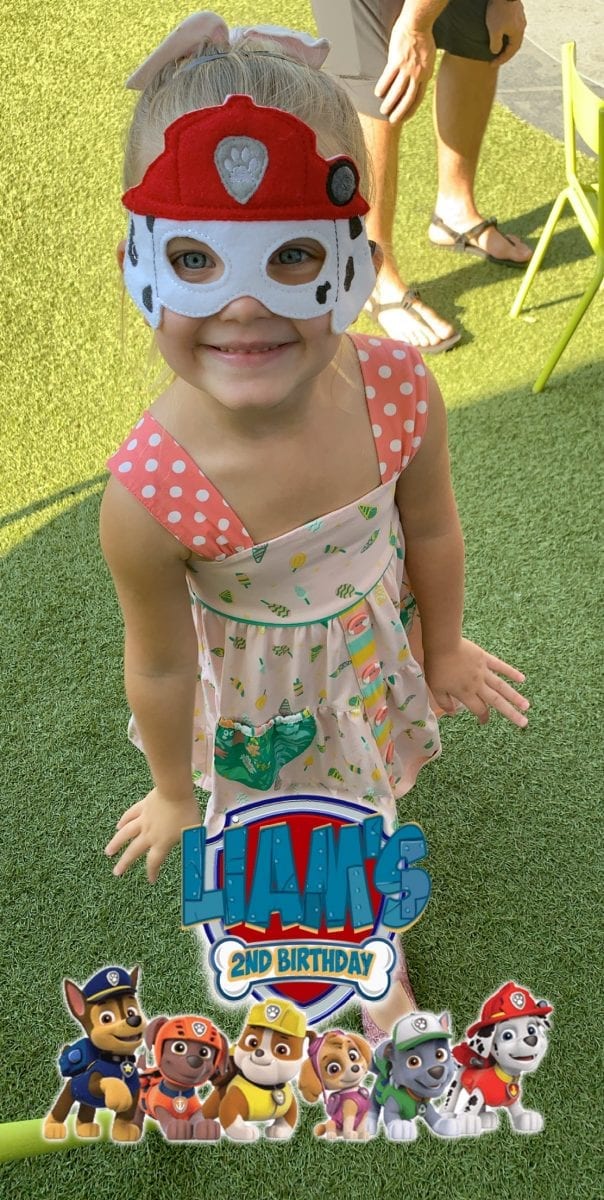 Little girl wearing a Paw Patrol felt mask with a Snapchat geofilter on the image.
