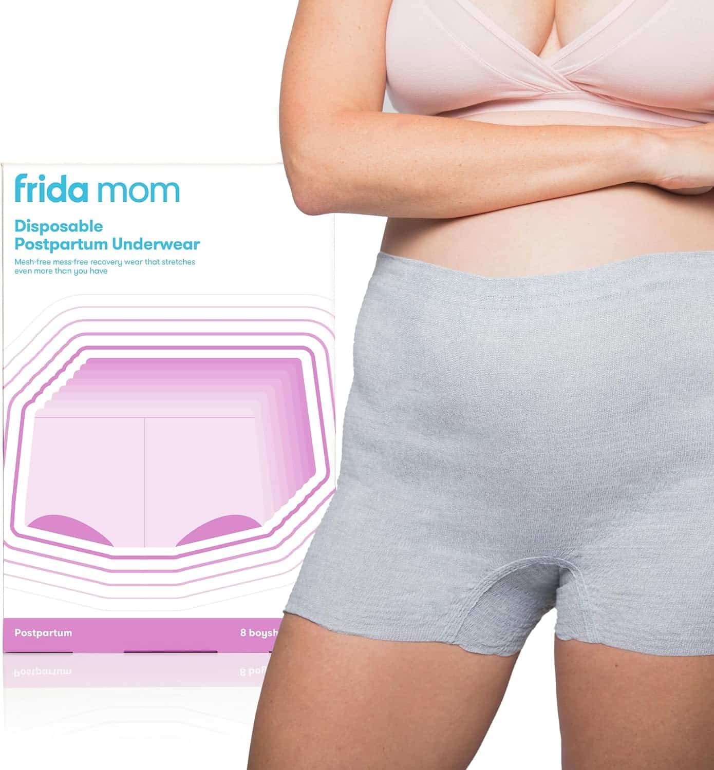 A person wearing light gray postpartum disposable underwear stands next to a box labeled frida mom Disposable Postpartum Underwear. Perfect for c-section recovery must-haves, the packaging features a diagram highlighting the underwears stretch and recovery use.