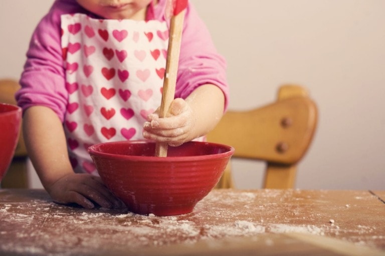 Little Girl Mixing Ingredients in Red Bowl.