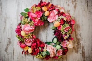 Beautiful spring composition of the big wreath of pink flowers decorated with little toy eggs especially for the Easter holiday