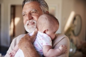 Hispanic grandfather holding his baby grandson.