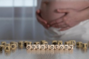 Word EPISIOTOMY composed of wooden letters. Pregnant woman in the background.
