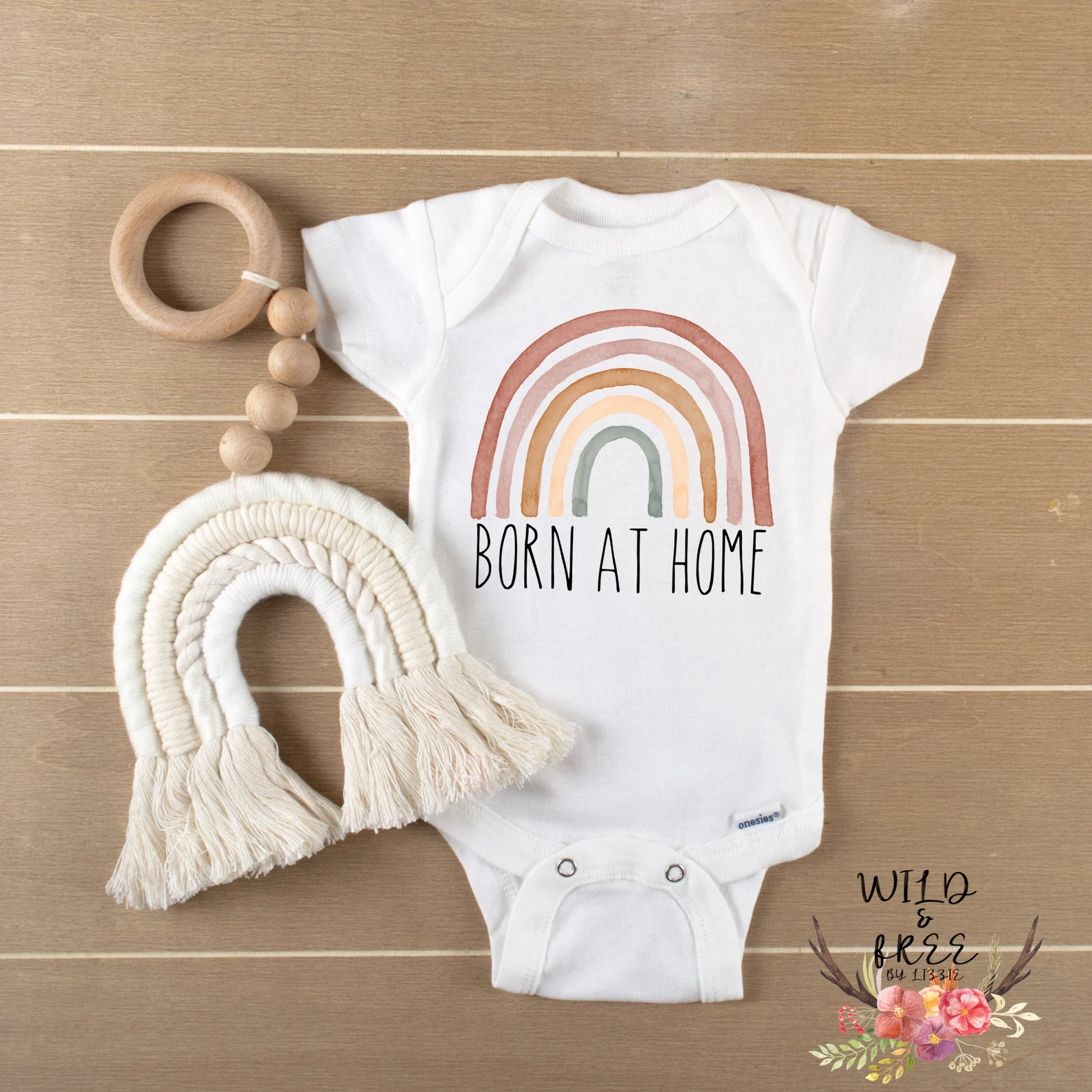 Born at home onesie with a rainbow on the design.