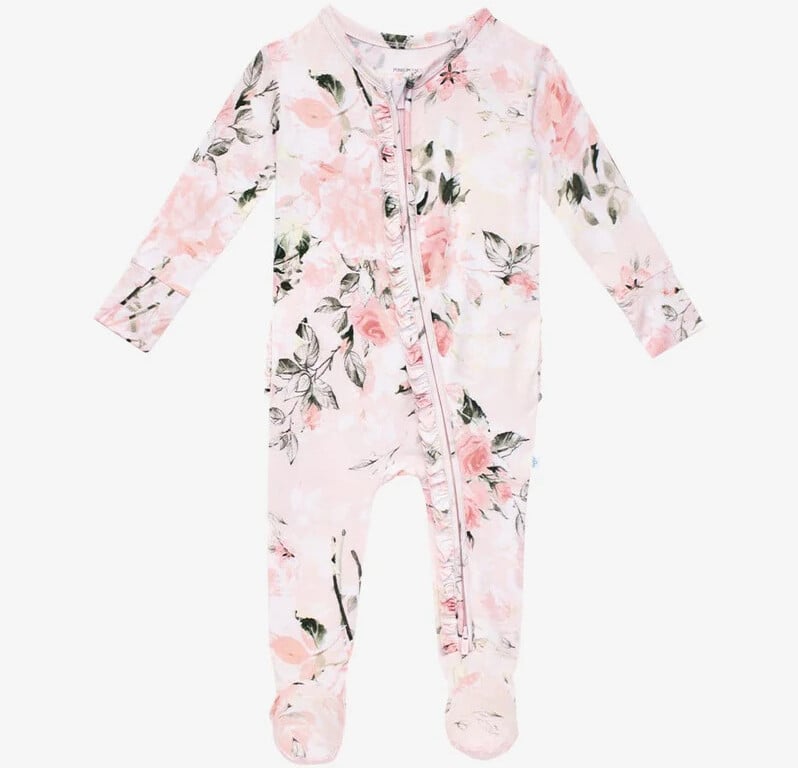 A long-sleeved floral baby onesie perfect for coming home outfits, featuring a convenient front zipper. The fabric displays a charming pink and green floral pattern on a light background and includes cozy foot coverings.