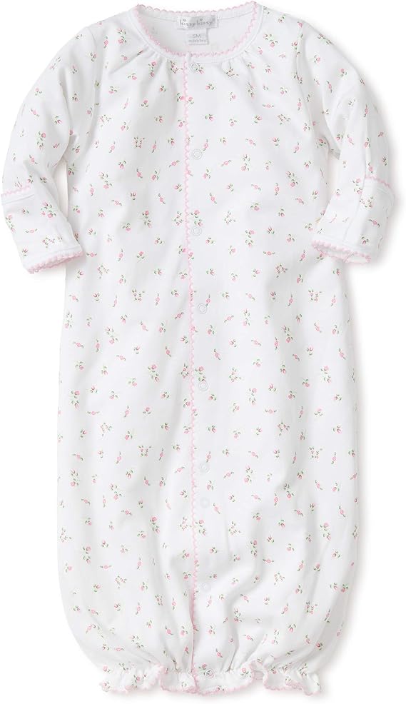 White baby sleep gown with long sleeves, adorned with small pink floral patterns. Perfect as a coming home outfit, the gown features pink scalloped edges and opens in the front with small snaps.