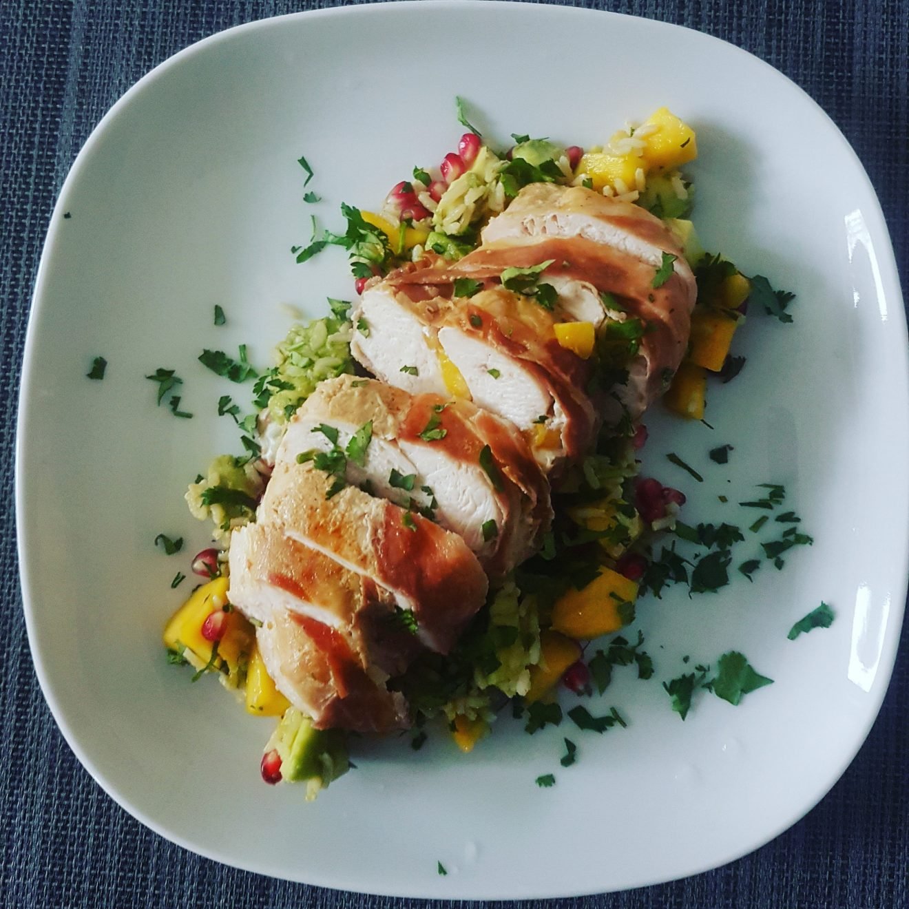 Mango Stuffed Chicken Wrapped in Prosciutto on a Bed of Avocado, Pomegranate, Mango and Wholegrain Rice Topped with Cilantro