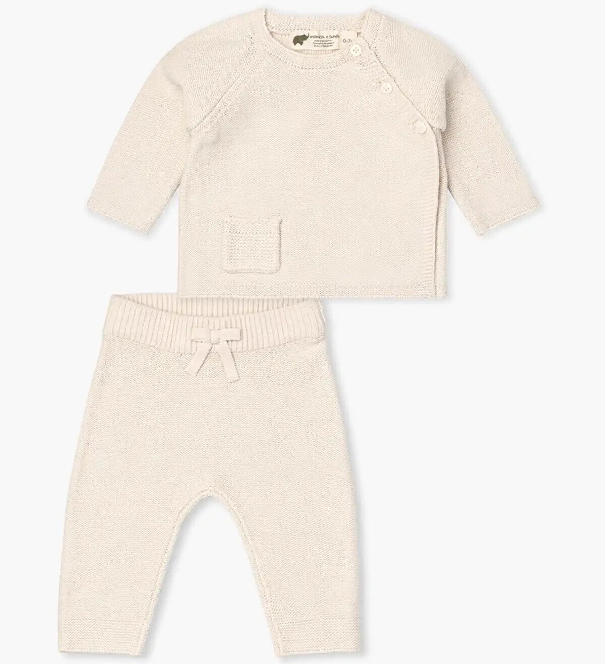 A beige baby coming home outfit featuring a long-sleeve knitted top with a front pocket and button details on the shoulder, paired seamlessly with matching knitted pants adorned with a charming bow on the waistband.