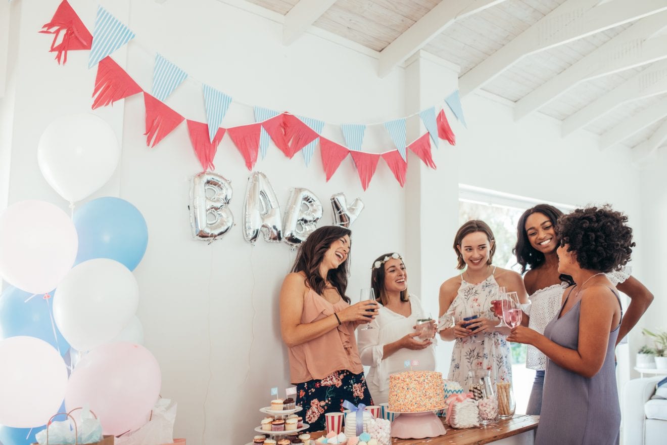 Group of multiracial women at a baby shower. Pregnant woman celebrating baby shower with female friends at home.