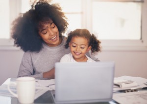 Young mother working and spending time with her daughter