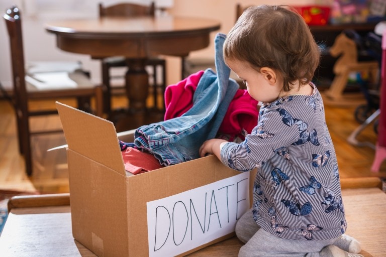Child sorting clothes for donation