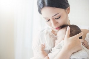 Close up portrait of beautiful young asian mother with her newborn baby.