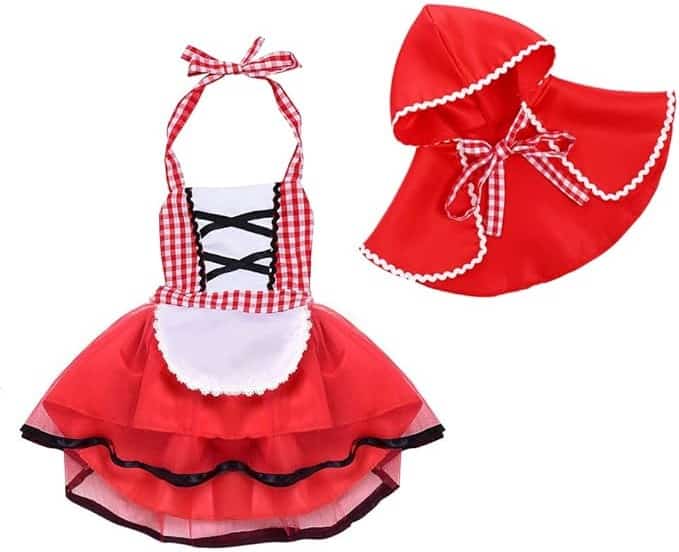 A childrens costume set perfect for Babys First Halloween Costume, consisting of a red dress with a checkered top, black lace-up front, and white apron. Its paired with a matching red hooded cape trimmed with checkered fabric and white lace, tied with a checkered bow.