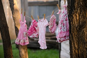 Clean, pink floral, and polka-dotted clothes on the clothesline outside.