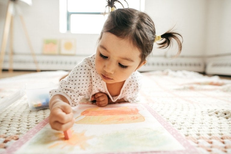 Little girl drawing with crayon.