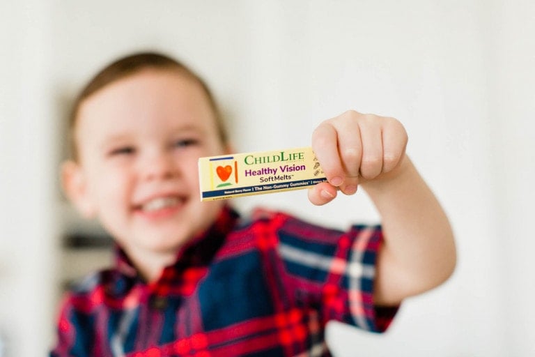 Little boy holding up ChildLife Essentials new Healthy Vision SoftMelts