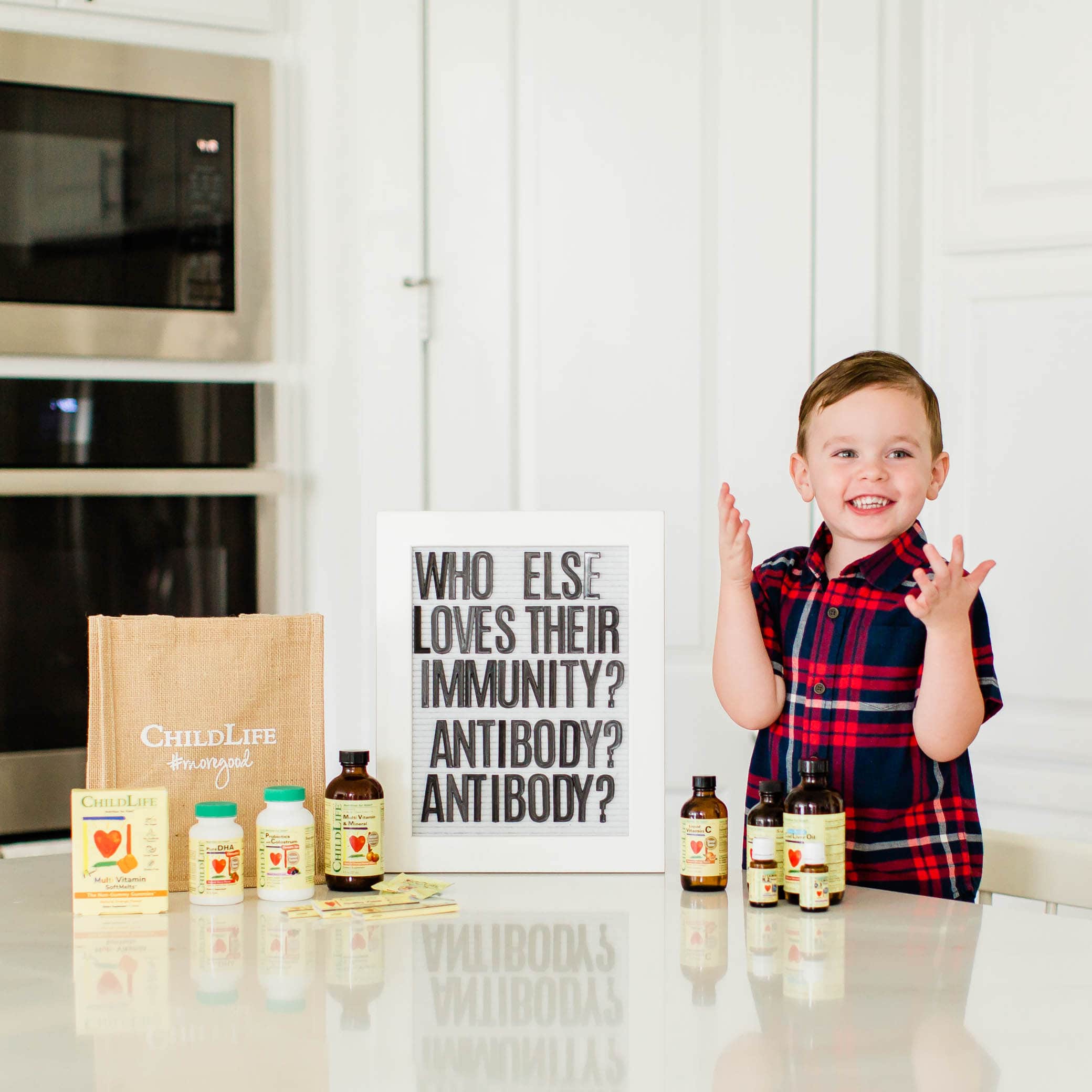 Little boy standing by a letter board with ChildLife Essentials Vitamins and Minerals 