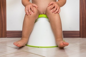 Child is sitting on baby potty - toilet training concept