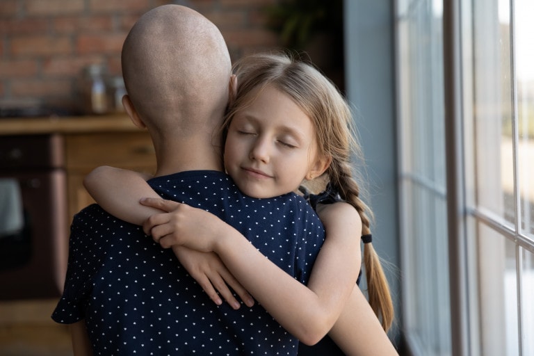 Caring daughter hugging her mother who is battling cancer.