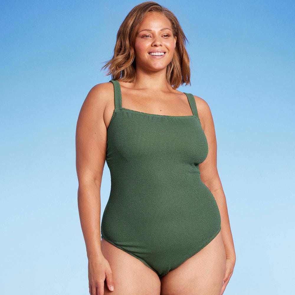 Woman in olive green one-piece bathing suit 