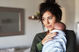 Shot of a cheerful young woman holding her little infant son at home during the day