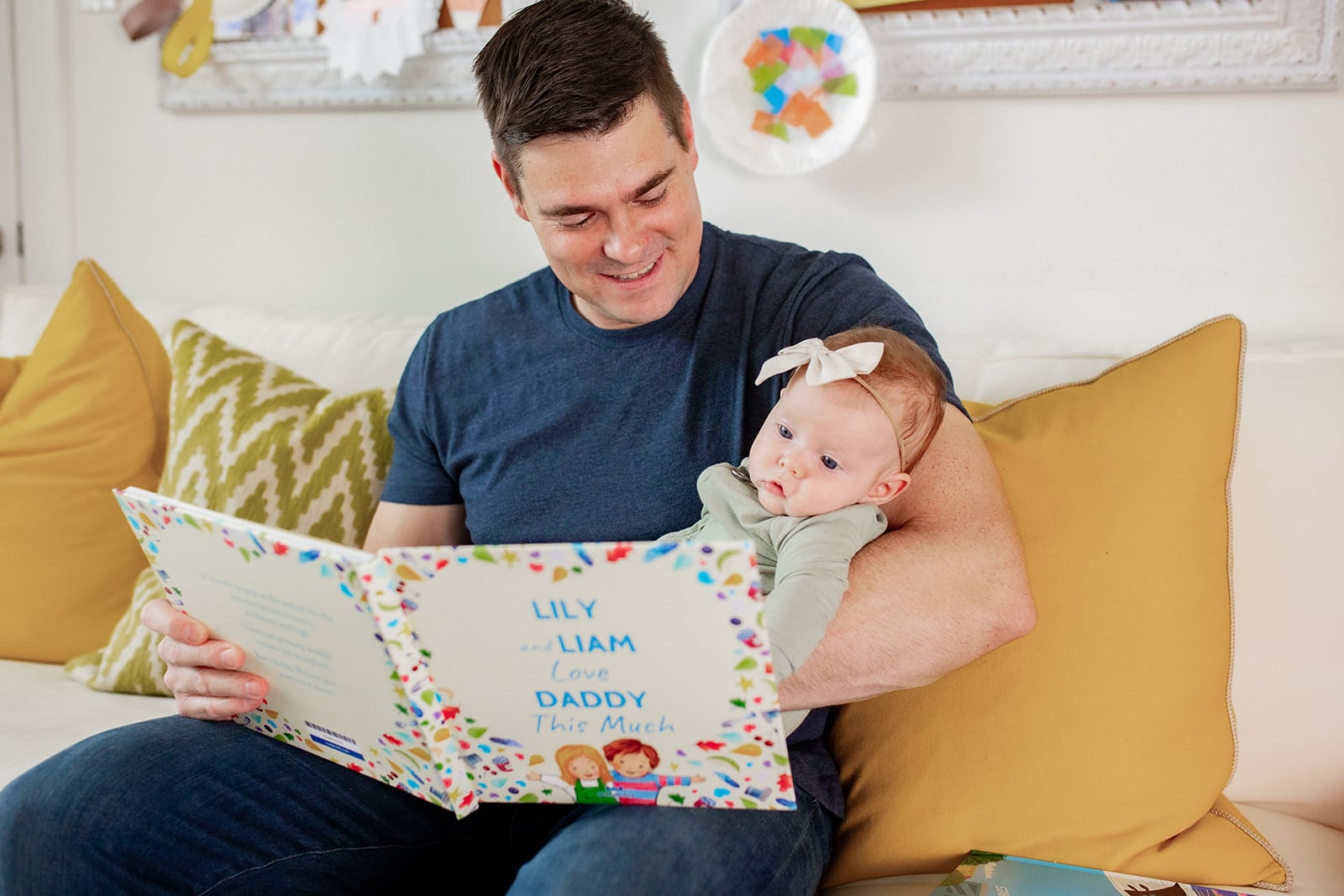 Father holding his baby girl while look at a Wonderbly personalized book