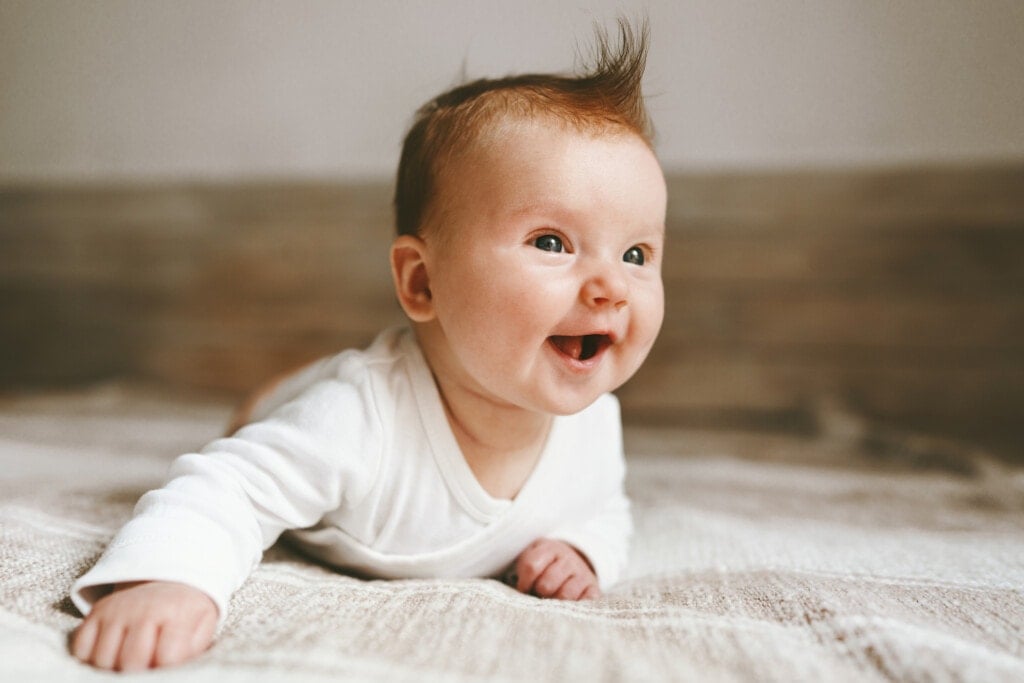 Smiling baby infant crawling at home adorable child portrait family lifestyle 3 month old kid