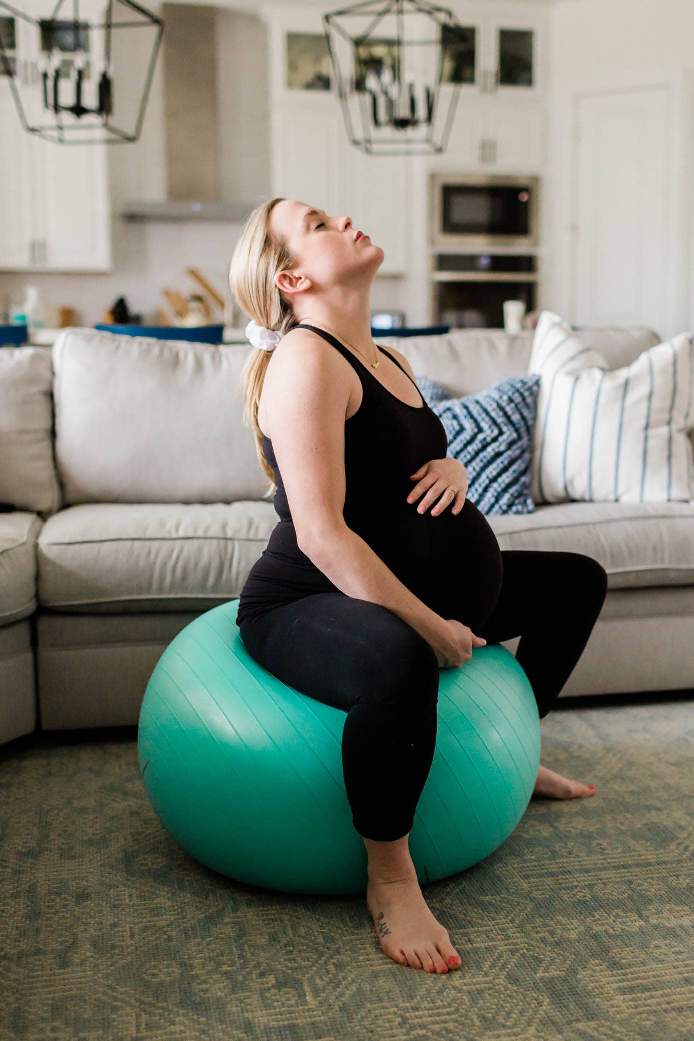 Pregnant woman sitting on a birth ball while in transition labor.