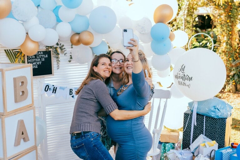 Female friends taking selfie with pregnant woman at a baby shower.