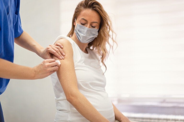 Applying a COVID-19 vaccine to a pregnant woman