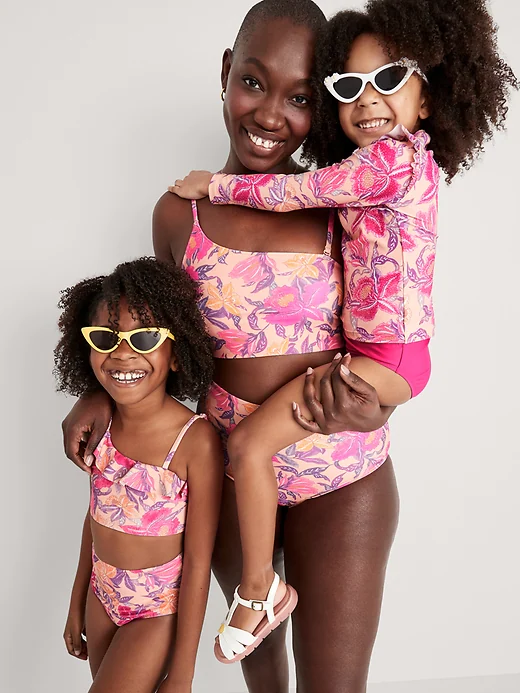 Woman with two children wearing matching peach and pink floral bathing suits