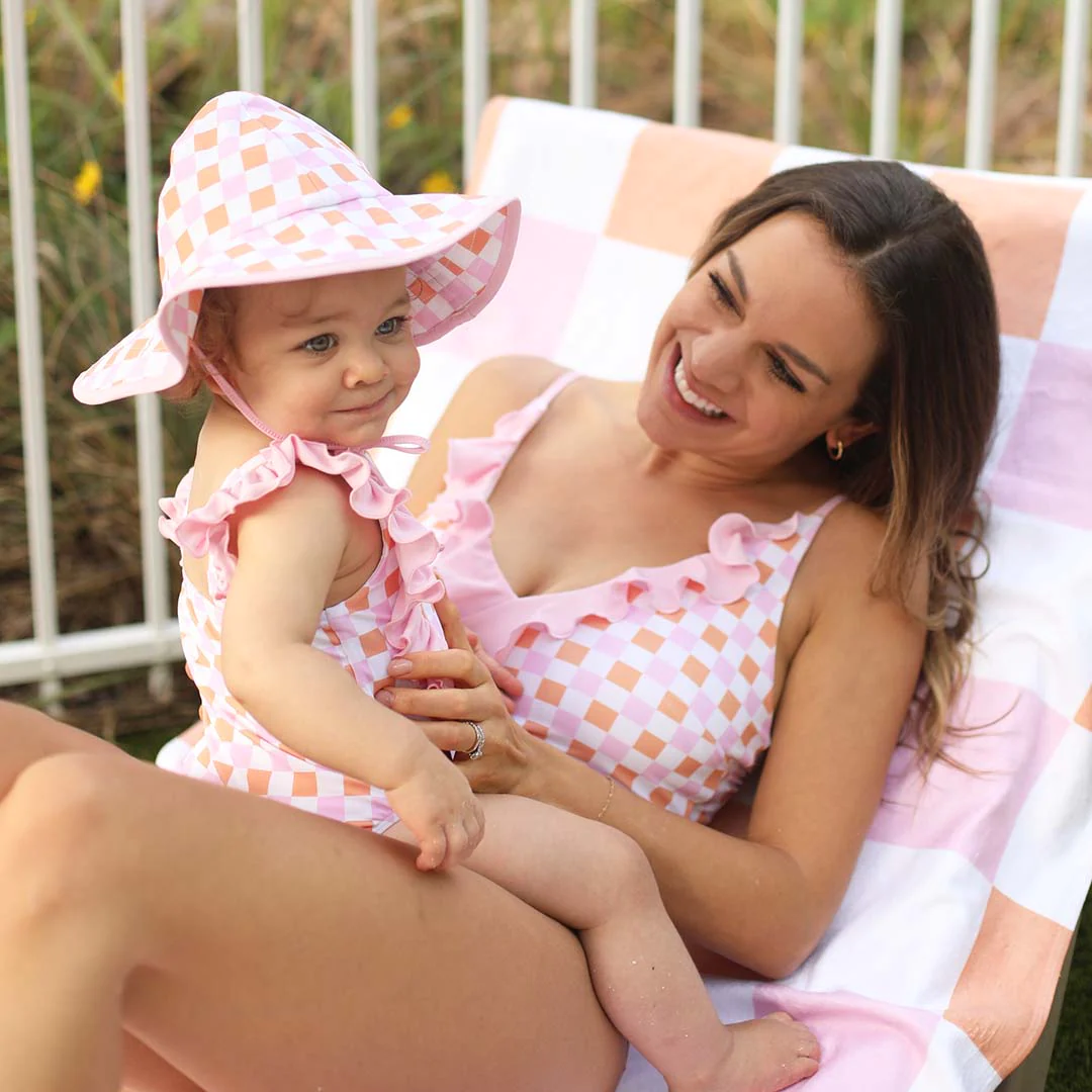 Mom and baby in matching pink checkered swimsuits 